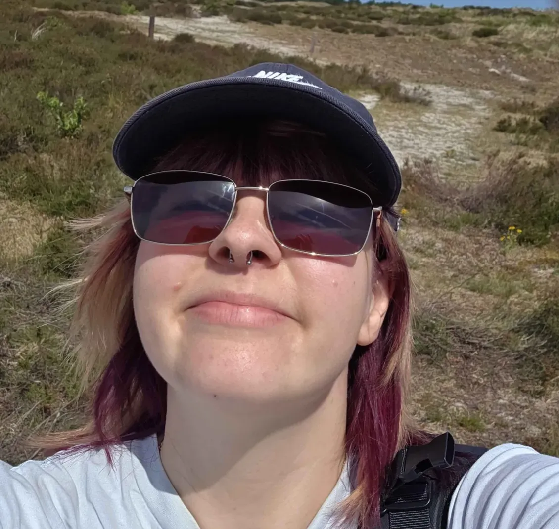 Image of the myth, the legend, me. With sunglasses and a hat, standing outside in the sun smiling.